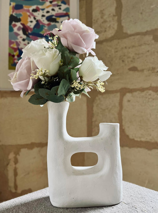 Vase sculptural blanc, asymétrique, fait à partir d'argile rouge.